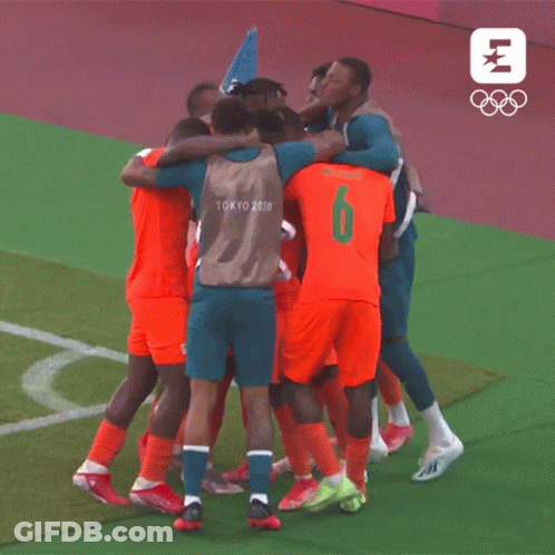 A Group Of Soccer Players Wearing Tokyo 2020 Jerseys Are Huddled Together GIF