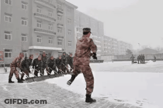 A Group Of Soldiers Are Clearing Snow From A Sidewalk GIF