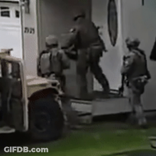 A Group Of Soldiers Are Getting Out Of An Ambulance In A Black And White Photo . GIF