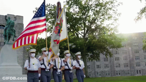 A Group Of Soldiers Are Holding Flags In Front Of A Building GIF
