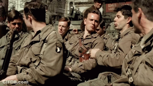 A Group Of Soldiers Are Sitting In Front Of A Sign That Says Source Of Lark GIF