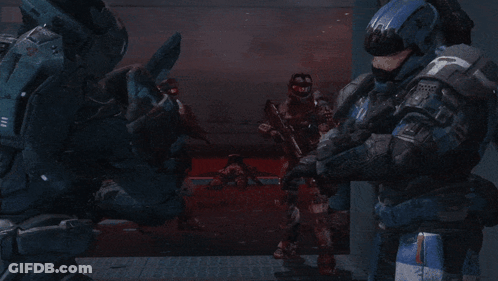 A Group Of Soldiers Are Standing In A Dark Room And One Of Them Is Wearing A Helmet With A T On It GIF