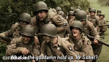 A Group Of Soldiers Are Standing In A Field And One Of Them Is Asking What Is The Goddamn Hold Up Mr Sobel . GIF