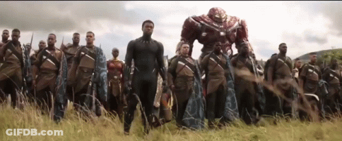 A Group Of Soldiers Are Standing In A Field With A Robot In The Background . GIF