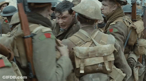 A Group Of Soldiers Are Standing In A Line And One Of Them Has A Red Patch On His Chest GIF