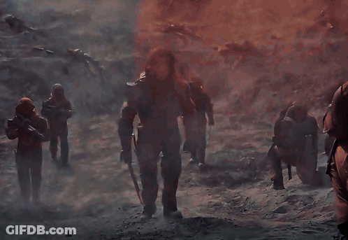 A Group Of Soldiers Are Standing In Front Of A Fire GIF