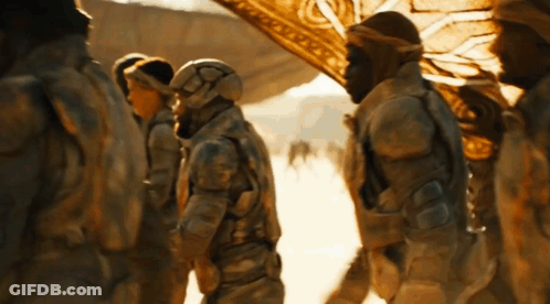A Group Of Soldiers Are Standing In The Desert And One Of Them Has A Helmet On GIF