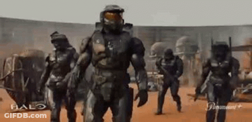 A Group Of Soldiers Are Walking In A Line In A Desert . GIF