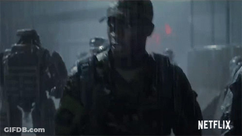 A Group Of Soldiers Are Walking In The Rain With A Netflix Logo In The Corner GIF