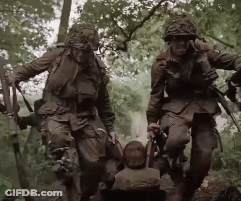 A Group Of Soldiers Carrying A Child In A Wheelchair GIF