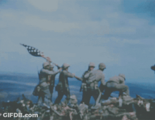 A Group Of Soldiers Holding An American Flag On Top Of A Hill GIF