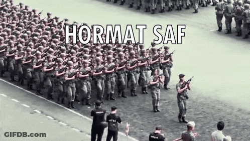 A Group Of Soldiers Marching Down A Street With Hormat Saf Written On The Bottom GIF