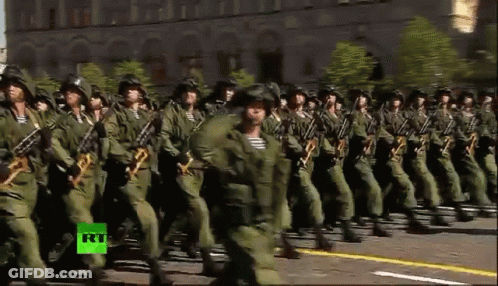 A Group Of Soldiers Marching In A Parade With A Green Rt Logo In The Corner GIF