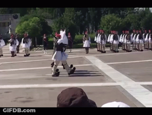 A Group Of Soldiers Marching In A Parade With A Man In A Costume That Looks Like A Horse GIF