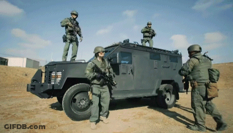 A Group Of Soldiers Standing On Top Of A Vehicle GIF