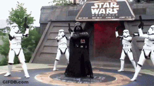 A Group Of Stormtroopers Are Dancing In Front Of A Sign That Says " Star Wars Weekends " GIF