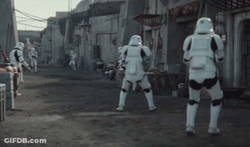 A Group Of Stormtroopers Are Standing On A Dirt Road GIF