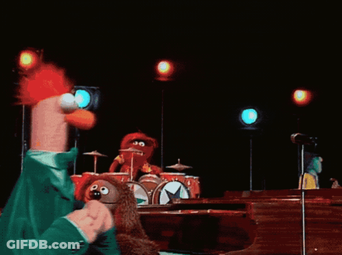 A Group Of Stuffed Animals Are On A Stage Including Beaker GIF