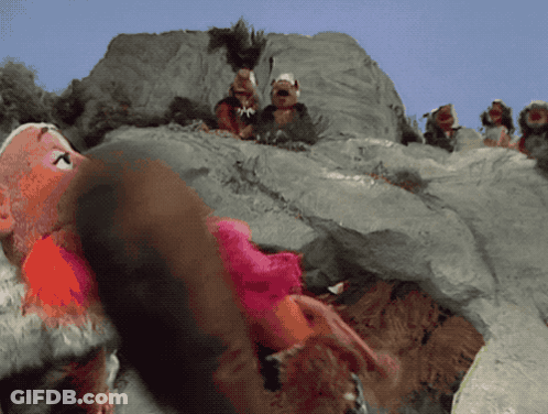 A Group Of Stuffed Animals Are Sitting On A Rocky Hillside GIF