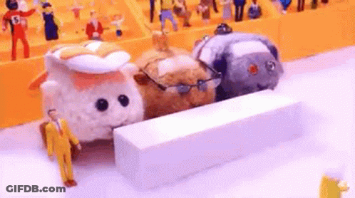 A Group Of Stuffed Animals Are Standing Next To Each Other On A White Surface . GIF