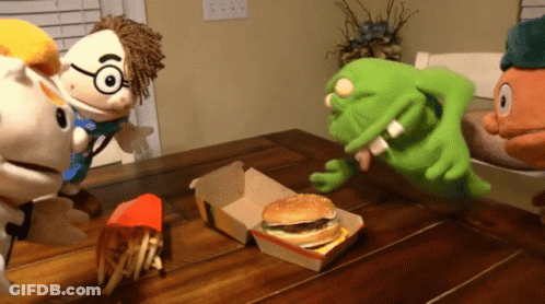 A Group Of Stuffed Animals Sitting Around A Table With A Mcdonald 'S Hamburger And French Fries GIF