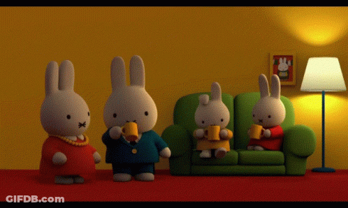 A Group Of Stuffed Rabbits Are Sitting On A Couch Drinking Coffee GIF