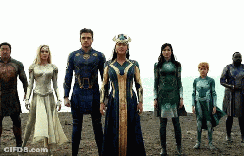 A Group Of Superhero Characters Are Standing On A Beach GIF