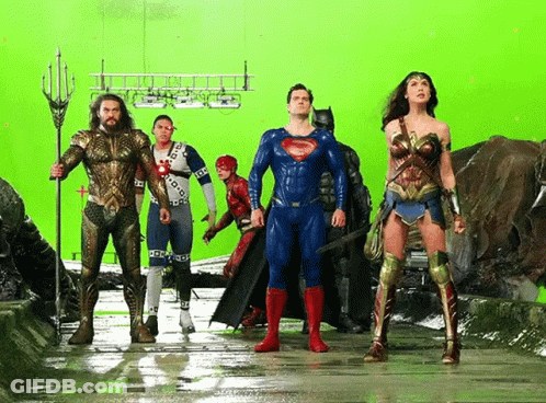 A Group Of Superheroes Standing Next To Each Other In Front Of A Green Screen GIF