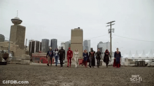 A Group Of Superheroes Walking In Front Of A City Skyline GIF