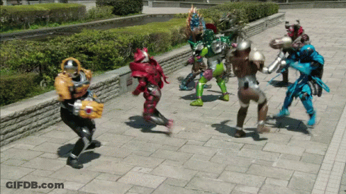 A Group Of Superheros Are Standing On A Sidewalk GIF