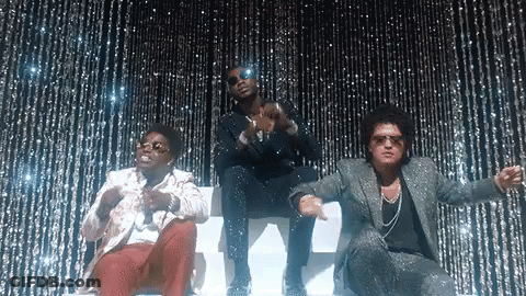 A Group Of Three Men Are Standing Next To Each Other In Front Of A Glittery Curtain . GIF
