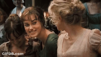 A Group Of Three Women Are Standing Next To Each Other In A Room And Smiling . GIF
