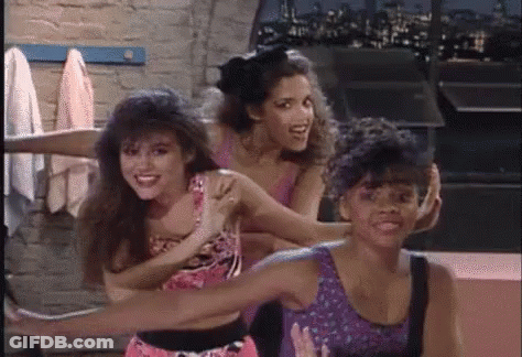 A Group Of Three Women Are Standing Next To Each Other In A Room And Smiling . GIF