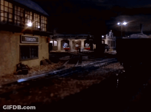A Group Of Train Engines Are Parked In A Garage At Night GIF