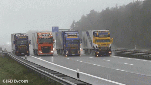 A Group Of Trucks Are Driving Down A Highway With A Sign That Says ' A / N ' On It GIF