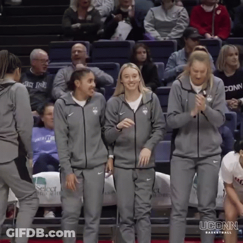 A Group Of Uconn Basketball Players Are Standing On The Court GIF