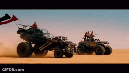 A Group Of Vehicles Are Driving Through The Desert GIF