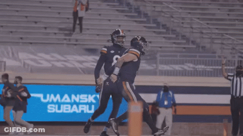 A Group Of Virginia Tech Football Players Are Huddled Together On The Field GIF