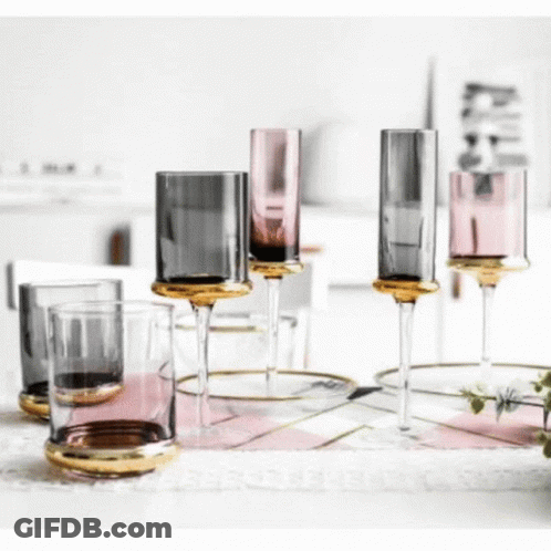 A Group Of Wine Glasses Sitting On Top Of A Table . GIF