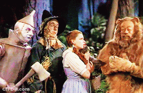 A Group Of Wizard Of Oz Characters Are Standing Together GIF