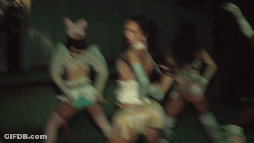 A Group Of Women Are Dancing In A Dark Room And One Is Wearing A Pink Cat Hat GIF