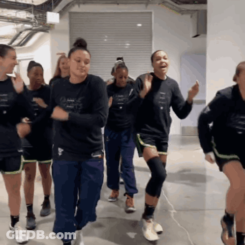 A Group Of Women Are Dancing In A Room And One Of Them Has A Shirt That Says Adidas GIF