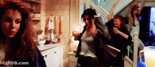 A Group Of Women Are Dancing In A Room With A Pitcher Of Beer In The Background . GIF