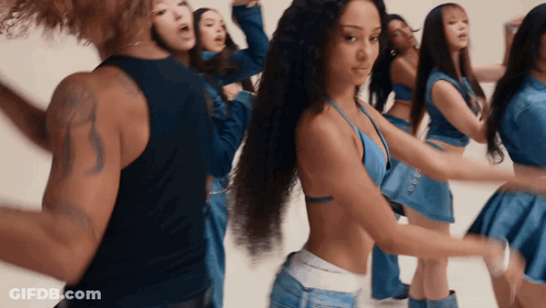 A Group Of Women Are Dancing In Blue Outfits With A Man In A Black Tank Top GIF