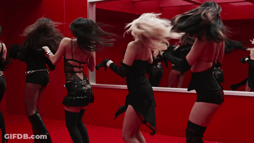 A Group Of Women Are Dancing In Front Of A Mirror In A Red Room GIF