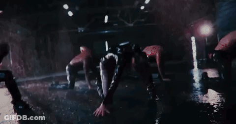 A Group Of Women Are Dancing In The Dark In A Dark Room . GIF