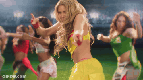 A Group Of Women Are Dancing On A Field With One Wearing A Yellow Top GIF