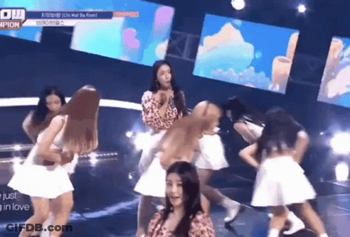 A Group Of Women Are Dancing On A Stage With A Sign That Says Champions GIF