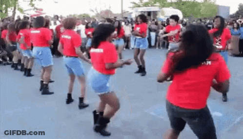 A Group Of Women Are Dancing Together In A Parking Lot . GIF