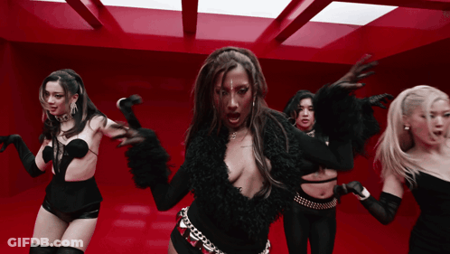 A Group Of Women Are Dancing Together In A Red Room GIF